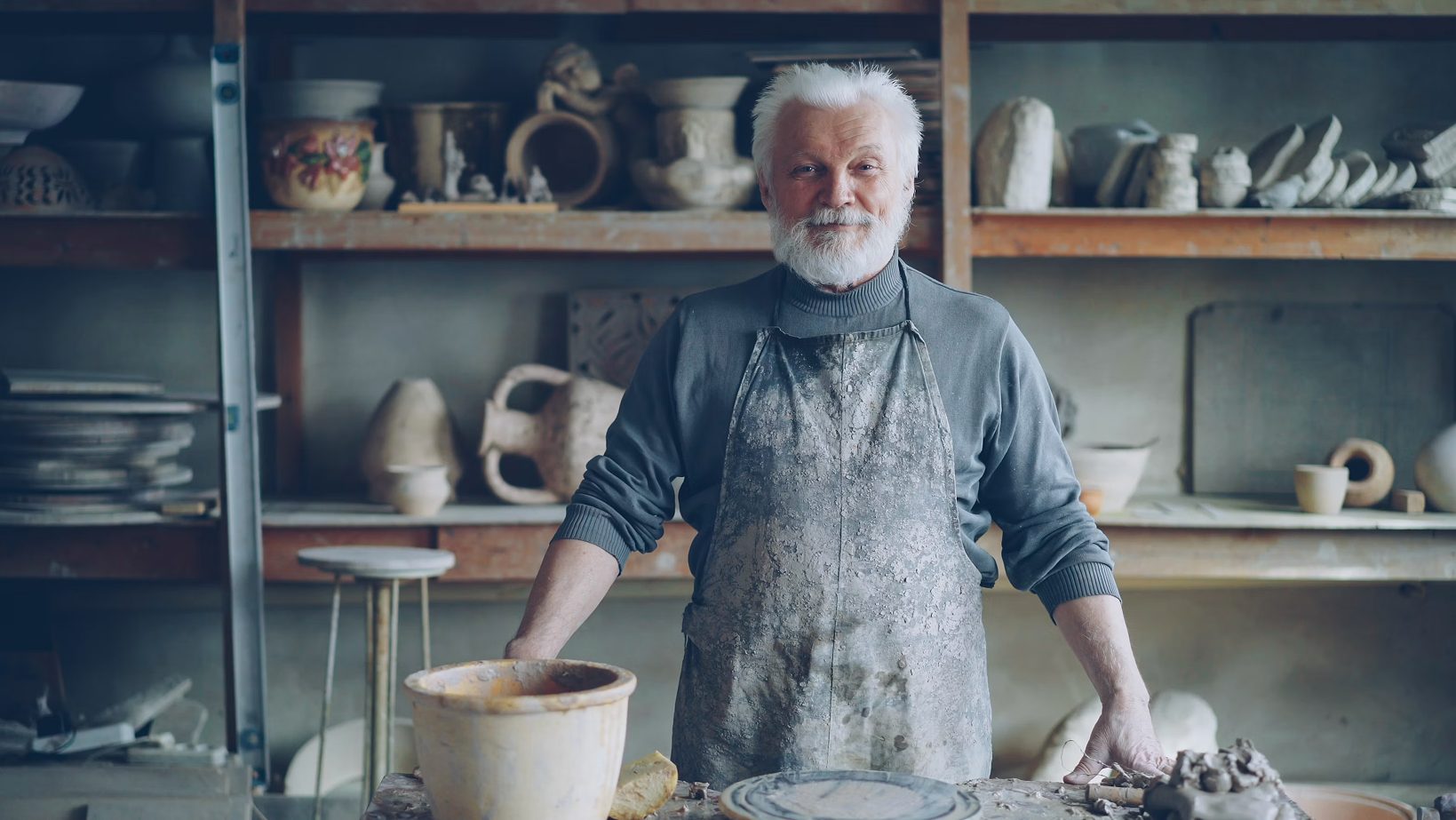 A potter in his workshop, surrounded by his work
